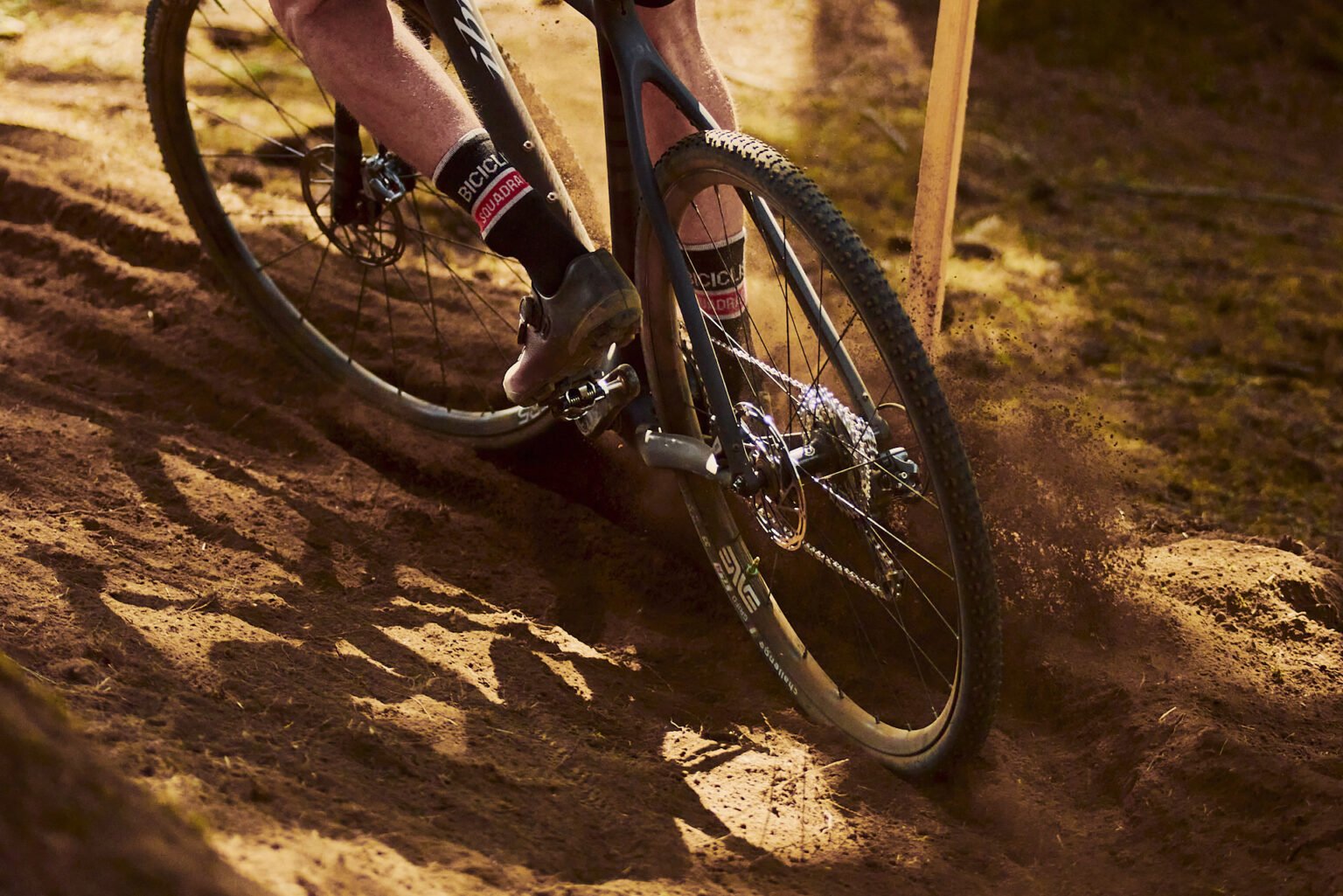 A cyclocross racer with Enve Wheels kicks up dust in a loose corner during Harvest Series Cyclocross Washougal MX Park Day 2 2023